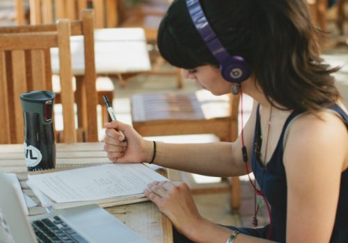 Woman studying with headphones on